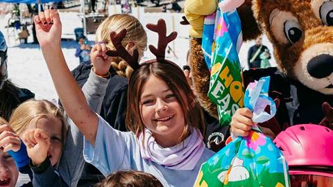 Smiling girl at June Mountain wearing and antler headband.