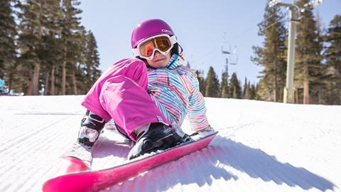 girl sitting in the snow after falling down
