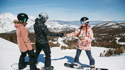 kids playing before taking a snowboard run