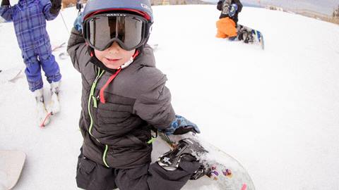 toddler boy kneeling in the snow