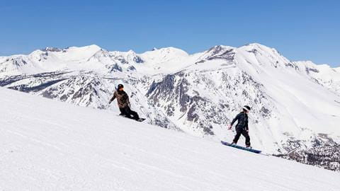 Two people snowboarding at June Mountain.